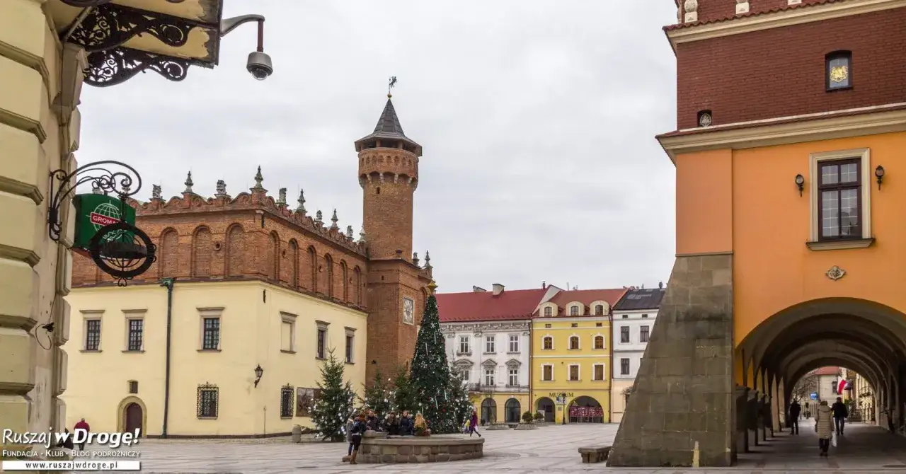 Tarnów atrakcje: Rynek z ratuszem, wieżą i kolorowymi kamieniczkami. W tle świąteczna choinka.
