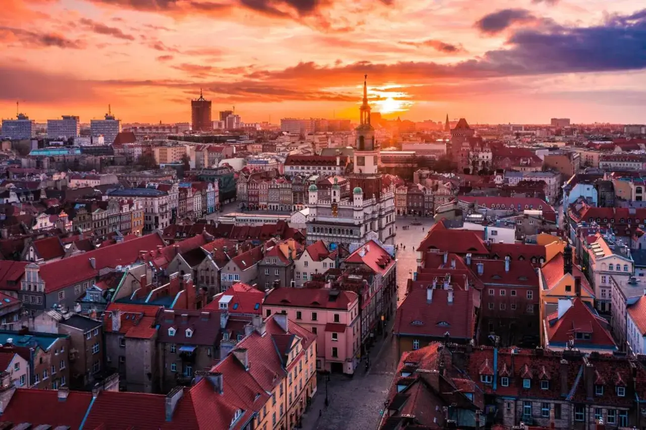 Zachód słońca nad Starym Rynkiem w Poznaniu. Widok na ratusz i kolorowe kamienice, które są jednymi z głównych poznańskich atrakcji.