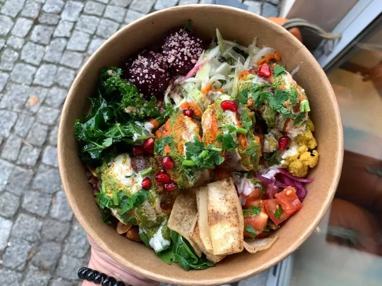 Kolorowy bowl z buraczkami, kalarepą, fetą i granatem. Idealne miejsce, gdzie zjeść w Warszawie, gdy masz ochotę na coś pysznego i zdrowego.