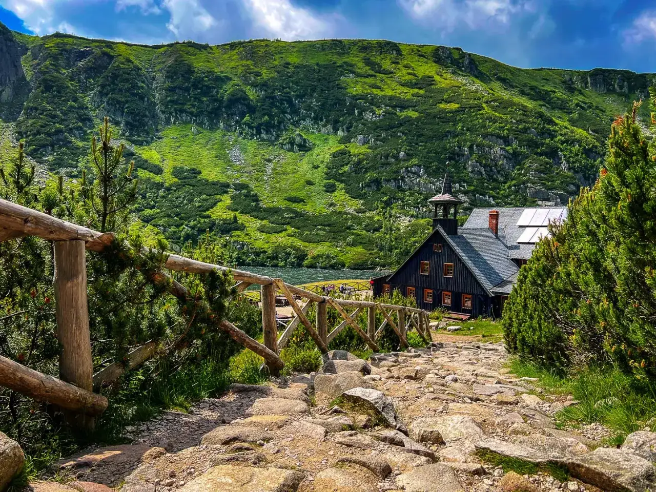 Kamienna karpacz trasa prowadzi do schroniska nad jeziorem, w otoczeniu zielonych gór.