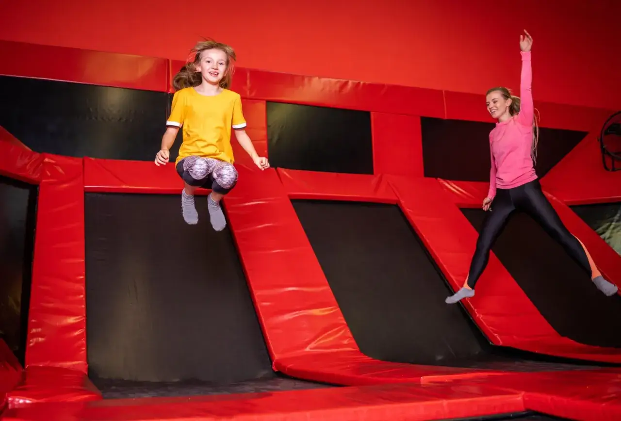Dzieci skaczą na trampolinach w polskim parku rozrywki. Radość i energia w powietrzu!