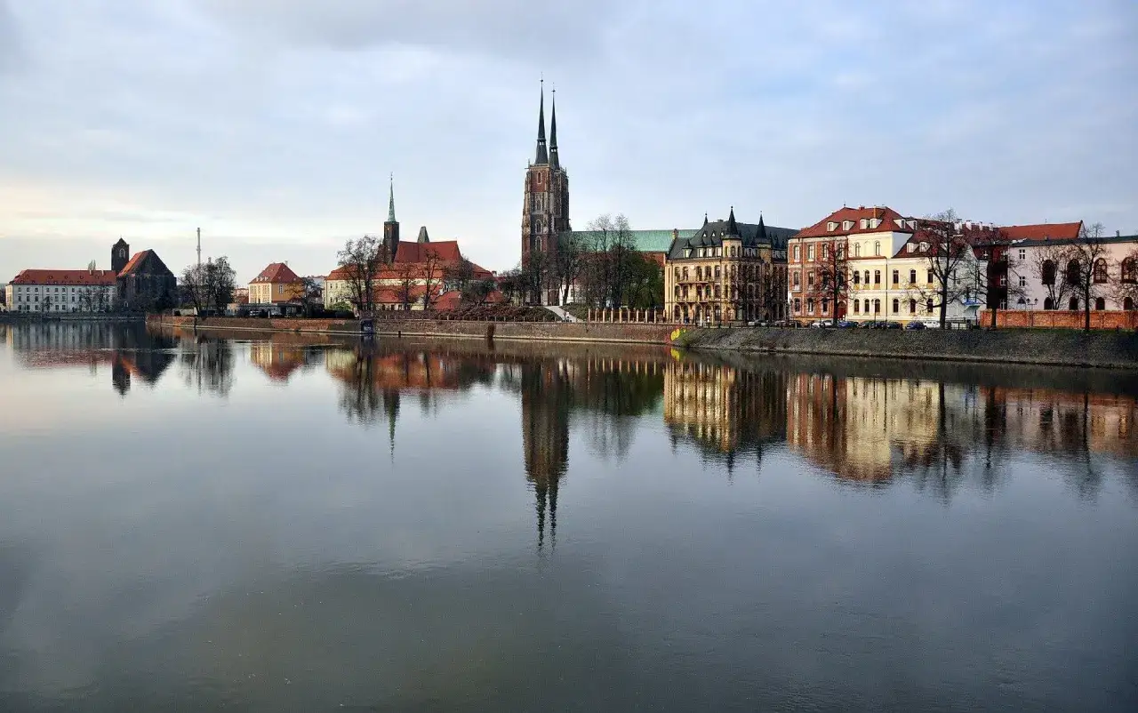 Wrocławski plan zwiedzania obejmuje malowniczy widok na Ostrów Tumski i zabytkowe kamienice odbijające się w wodzie.