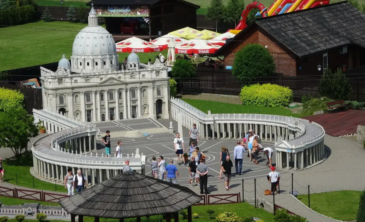 Miniaturowa Bazylika św. Piotra i Plac Świętego Piotra w jednym z parków miniatur w Polsce. Ludzie spacerują wokół.