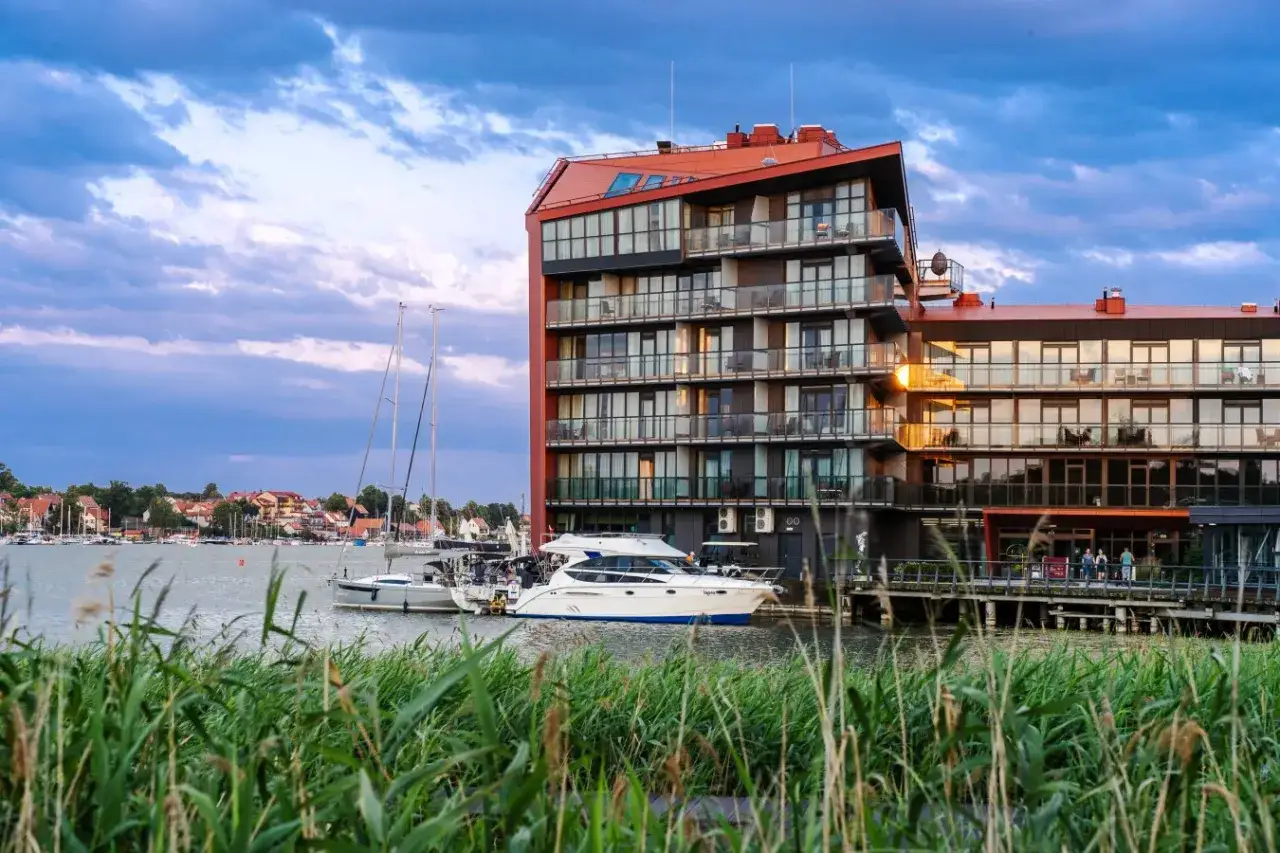 Nowoczesny hotel nad jeziorem, z jachtami przy kei. Idealne miejsce na wypoczynek, bon Warmia Mazury czeka!