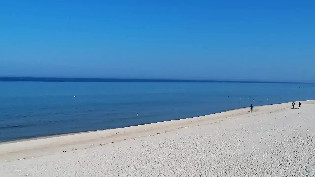 Spokojna plaża, błękitne niebo i morze. Spacerowicze cieszą się urokami Grzybowa.